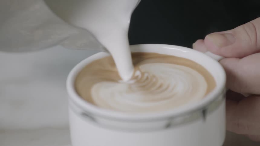 Milk is being poured in a mug