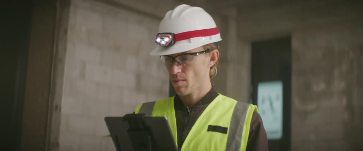 A man is using a tablet outside the building