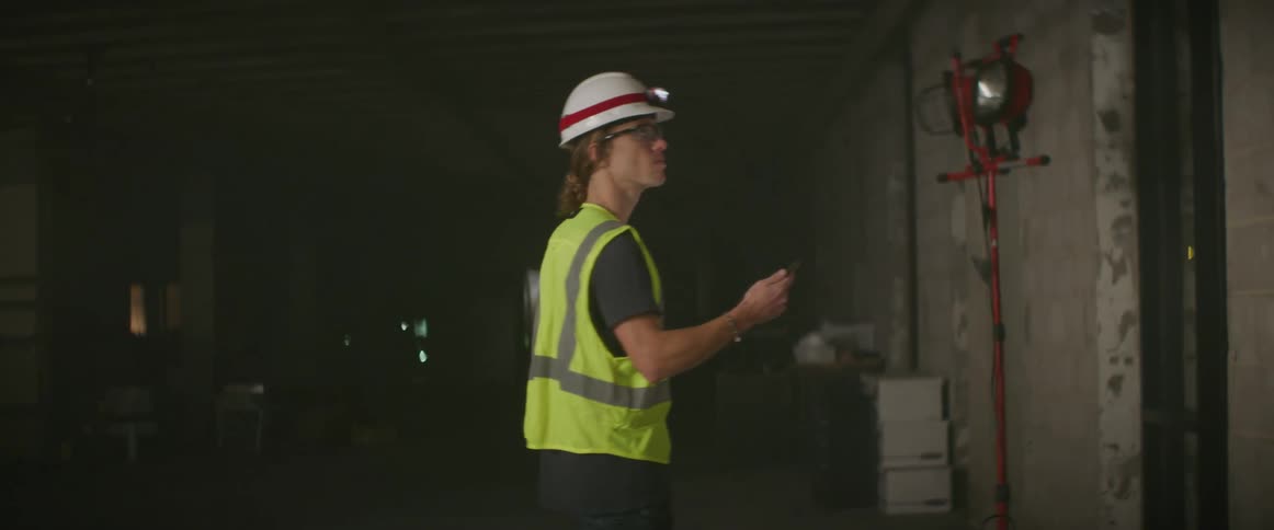 A man uses a tablet and points around the building