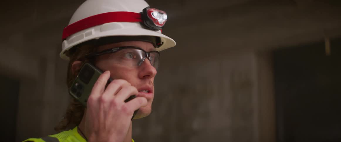 A construction worker talks on a cell phone