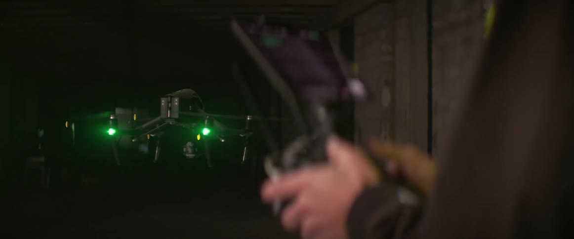 A man controls a drone inside a building