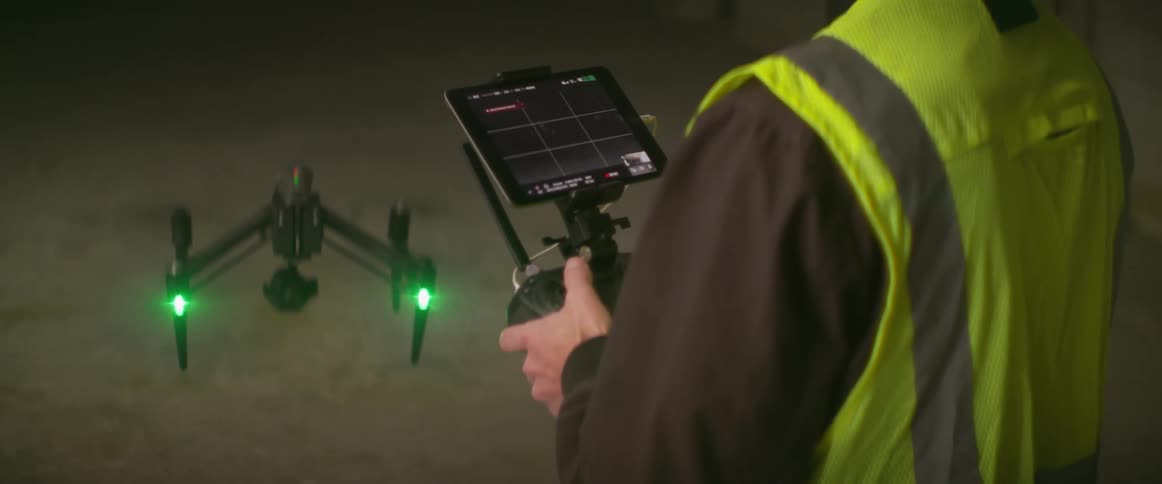 Man controls drone hovering near floor in construction site