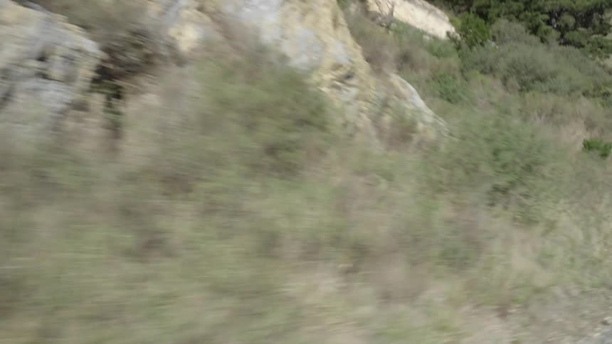 Moving fast down a dirt road near a tall hill