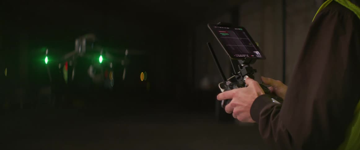 A man operates a drone outside at night