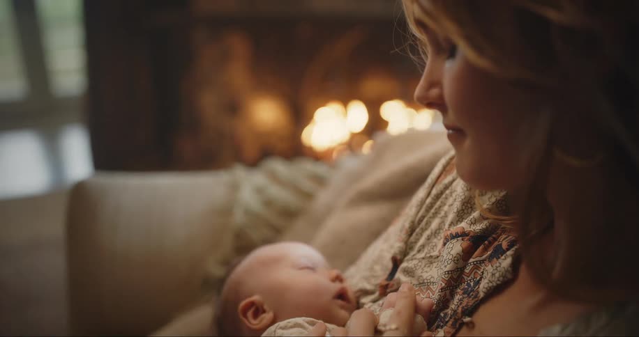 Mother and newborn by the fire at home