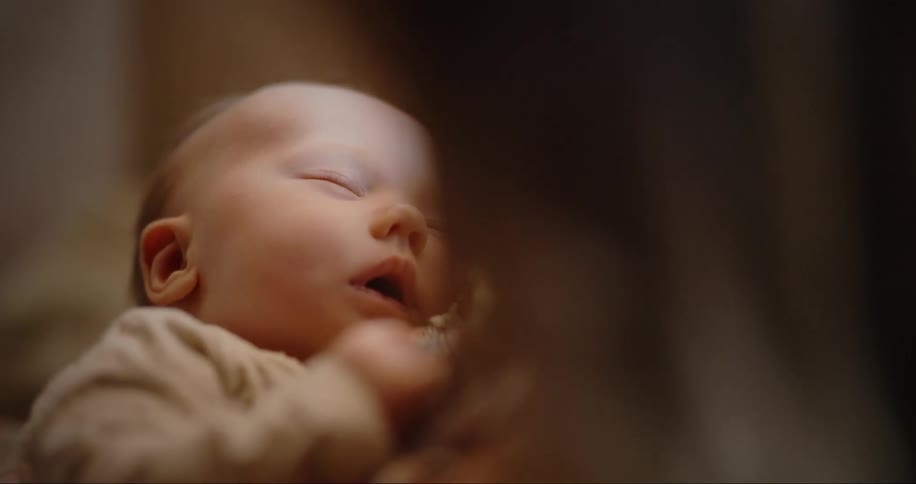 Mom holds her newborn baby as she sleeps