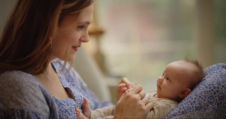 Mother sitting smiling at her baby in her lap