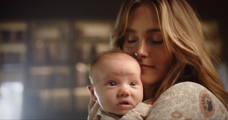 Young mother kisses her baby on forehead