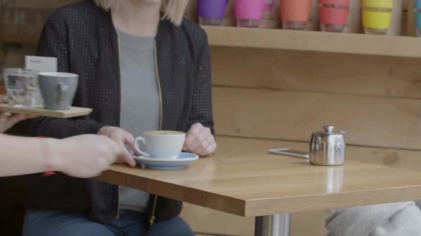 Coffee is served to customer by a waitress