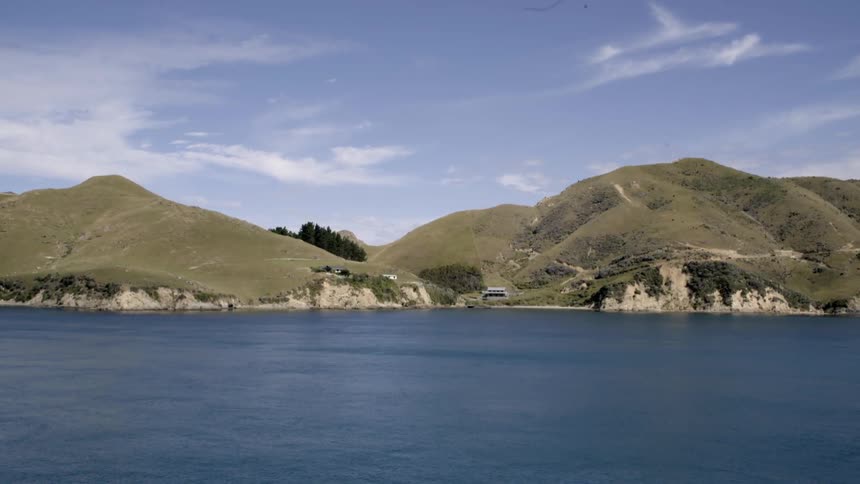 A large lake is lined with hills covered with grass