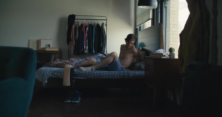 Man wakes up and sits up in bed next to his prosthetic leg