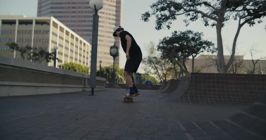 A male skateboards through a public park