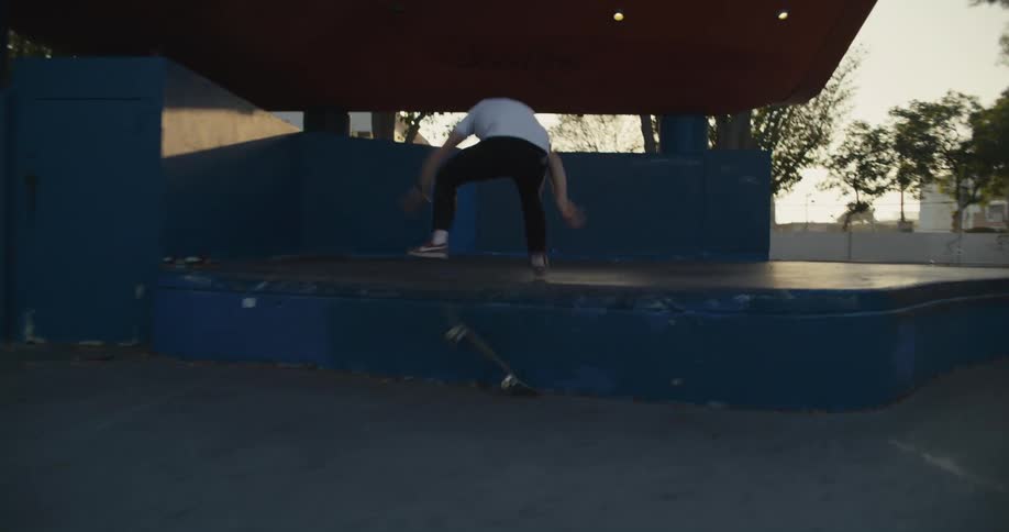 One skateboarder watches another attempt a trick and fail