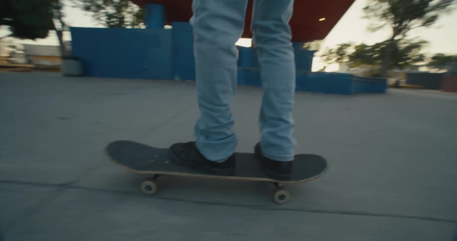 A man does a jump trick on his skateboard as his friends watch