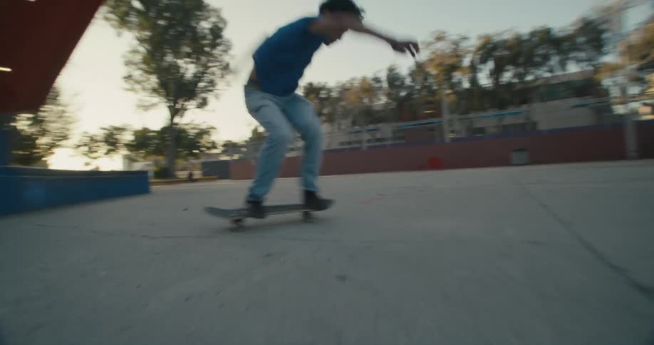 A teenage boy jumps and flips his skateboard as he skates at a public park