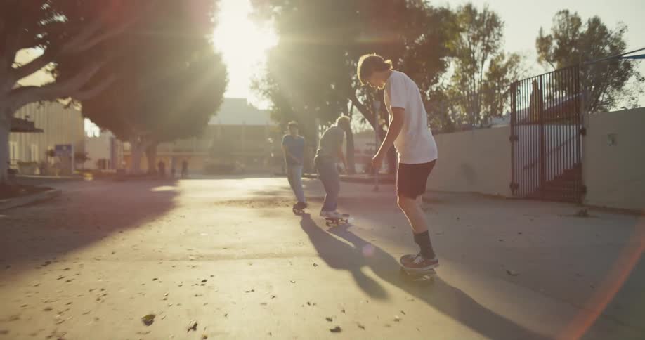 Three teenagers skateboard at a public park