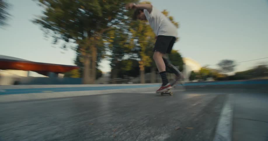 Skateboarder jumps up and down flat platform in park