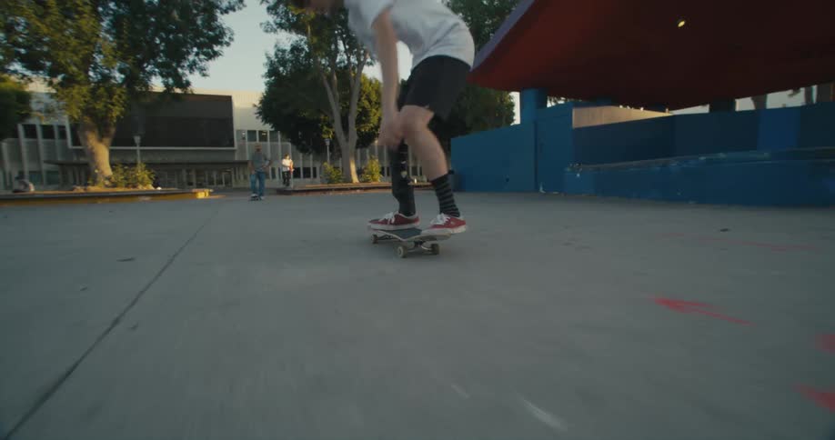 People skateboard and walk at a public park