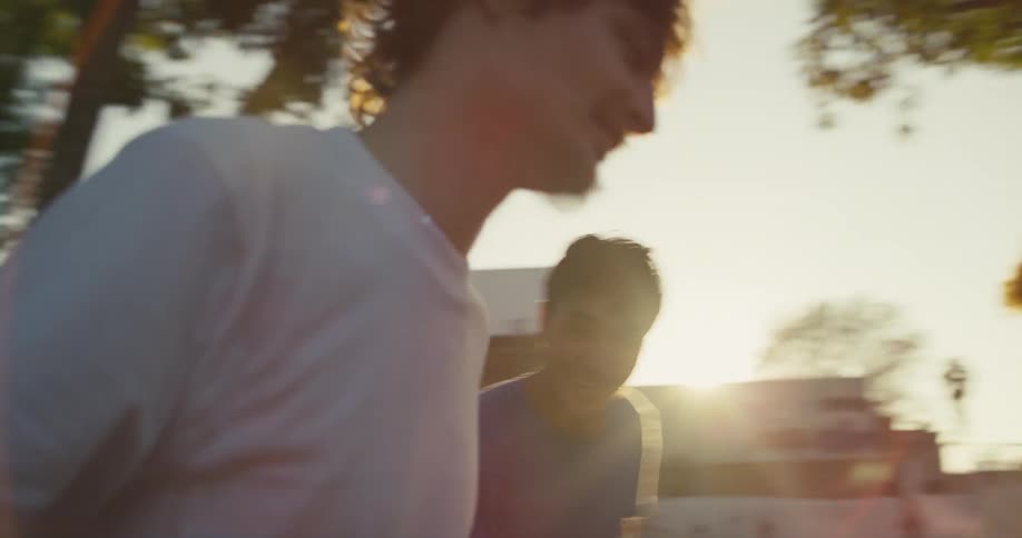 A man high fives and fist bumps his friends after a skateboarding stunt