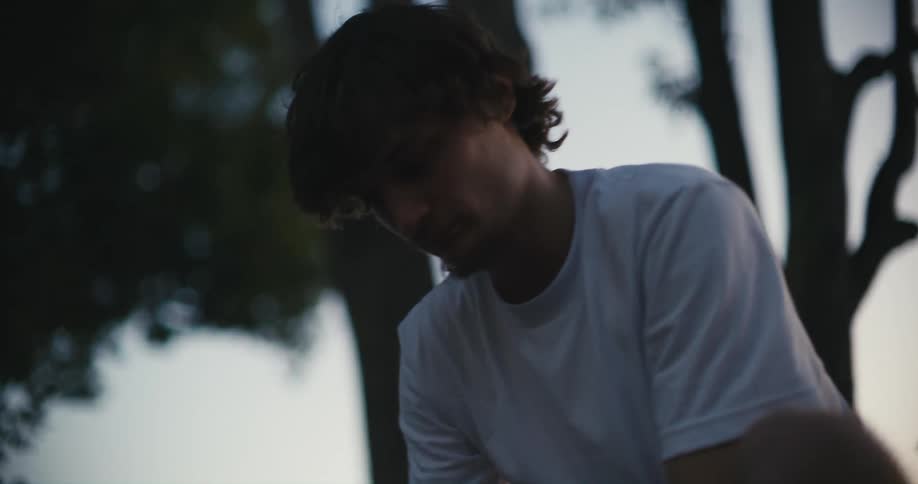 Young man leans over making adjustments before straightening his posture