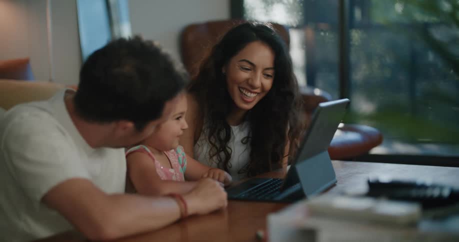 A family sitting around at a table with a tablet