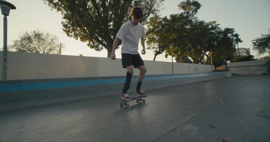 A teenager falls off his skateboard after attempting to jump over steps