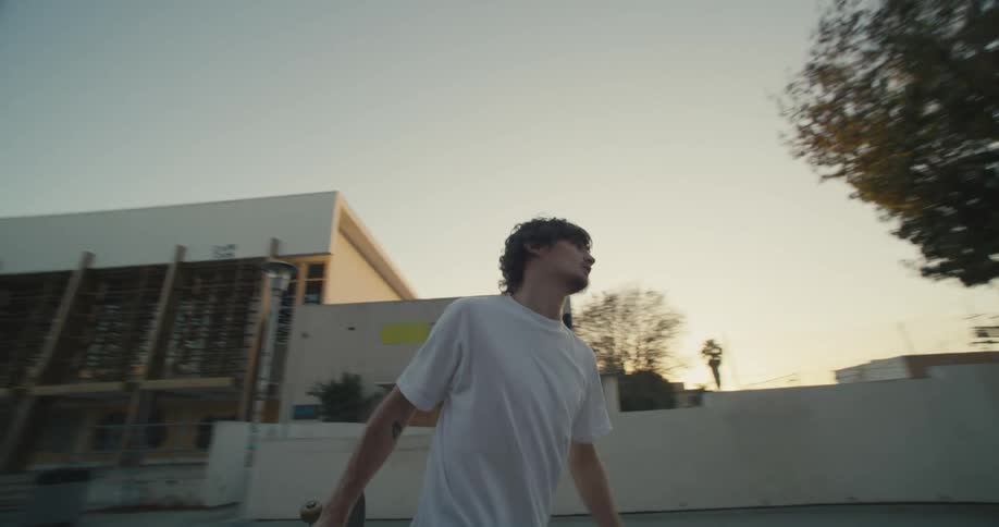 Skateboarding male wearing leg prosthetic fails a trick and throws skateboard