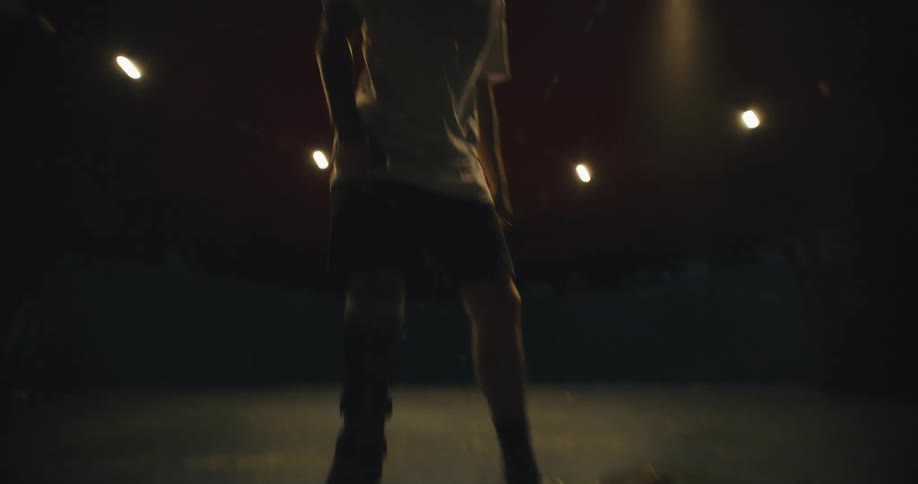 Man with leg brace jumps on skateboard then throws pieces down on ground before walking away at night