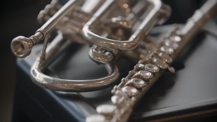 Light reflects off a french horn on a table