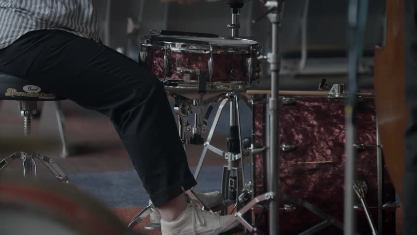A person is sitting playing drums