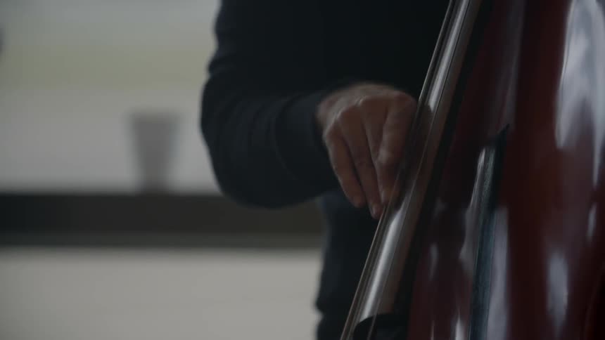 A man is pulling the strings on a musical instrument