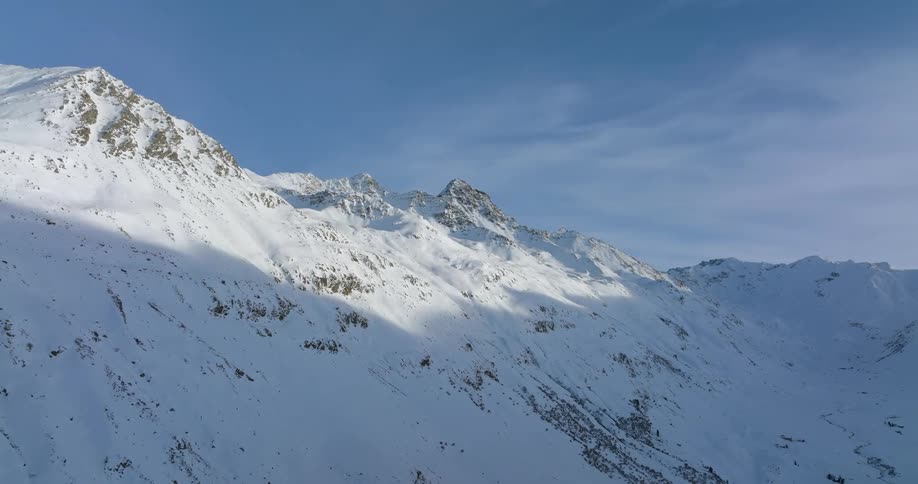 A snow covered rocky mountain ridge on a sunny day