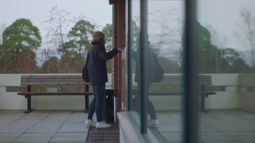 A woman swipes a card and opens the door to an office building