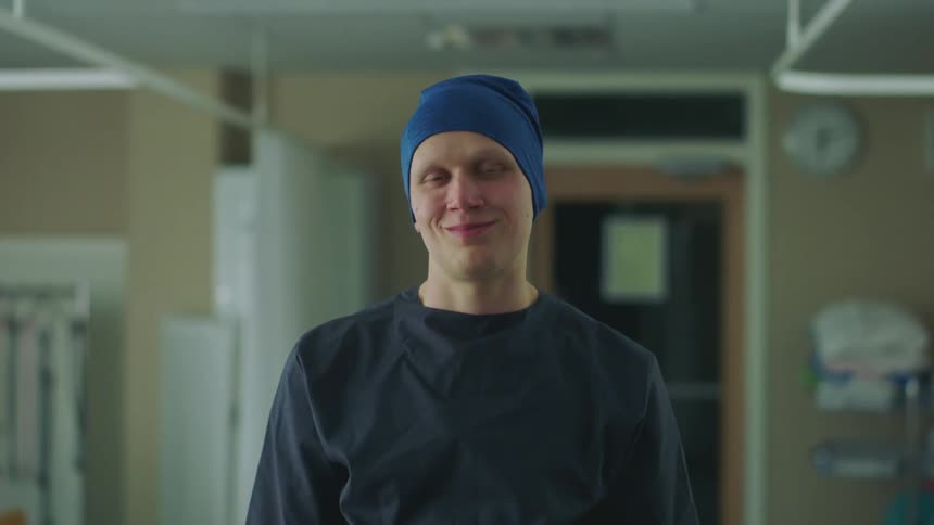 Male patient stands in hospital room posing and smiling
