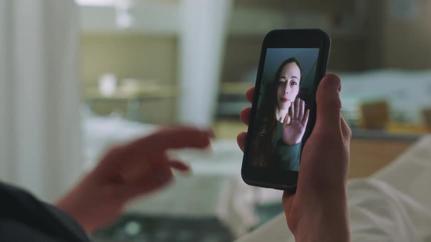 A woman waves on the cell phone