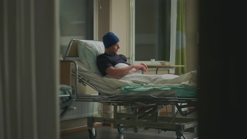 A hospital patient talks on his cell phone