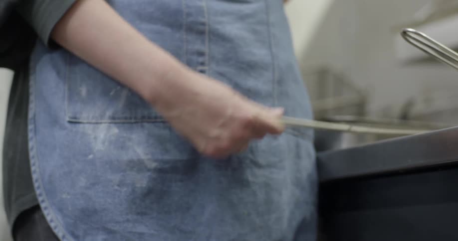 A woman is using a deep fryer