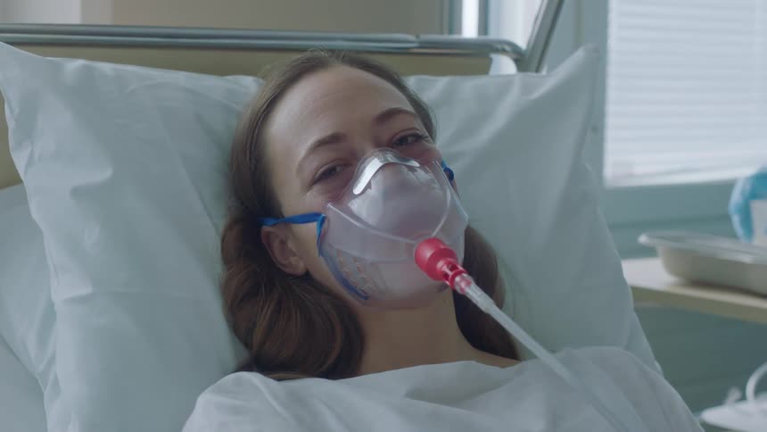 A patient has a breathing mask on in the bed