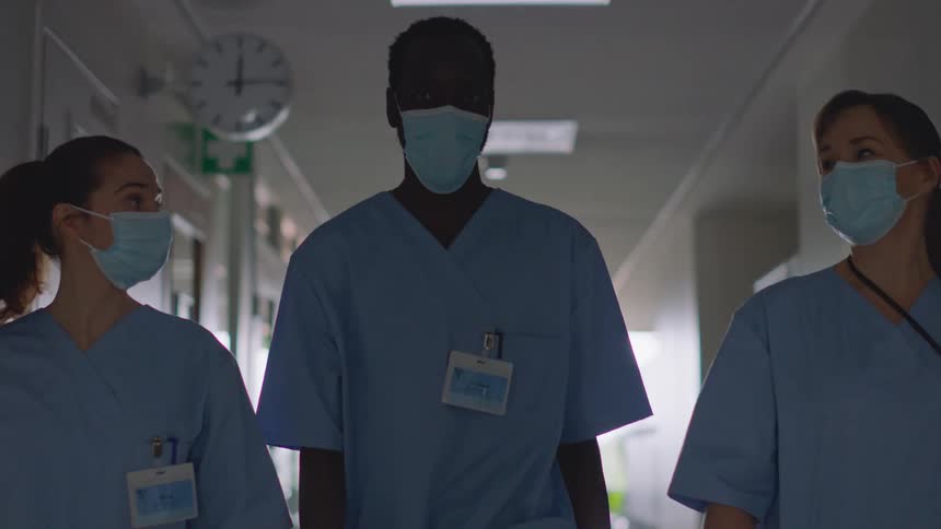 Hospital staff walk down the hall talking