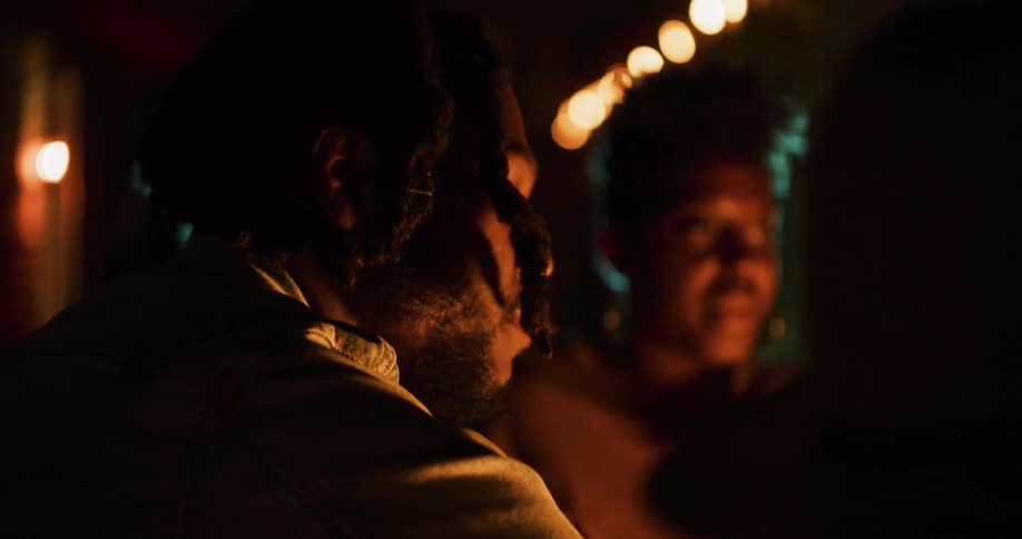 Family talking while sitting around the fire outdoors at night