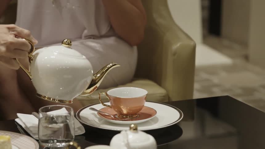 People are seated as tea is poured
