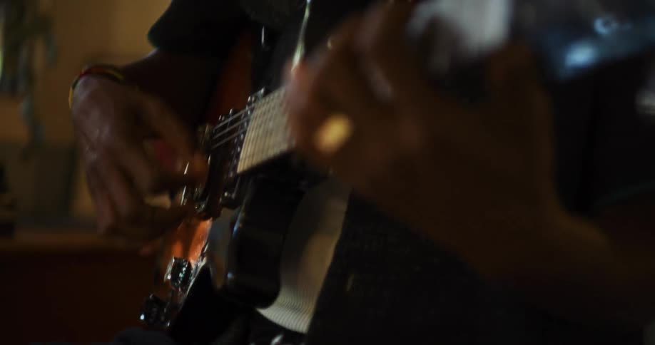 Guitarist plays guitar near kitchen