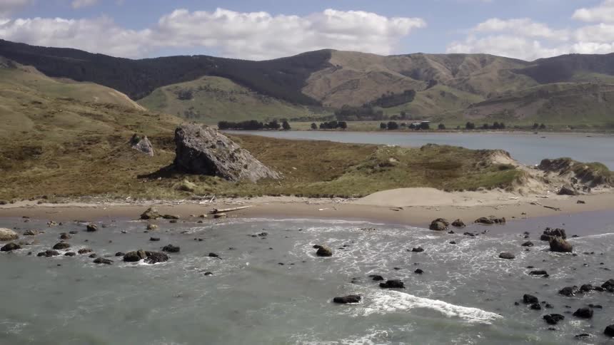 Aerial view of a shoreline with rough water and rocks