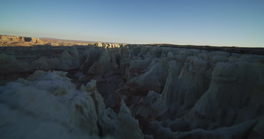 A man hikes along the top of the cliff in the canyon