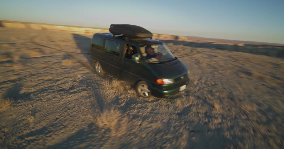 A man drives a van in circles in the desert