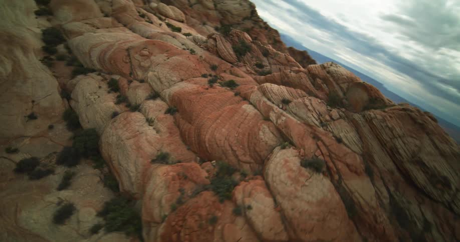 Vegetation dots reddish stone terrain in badlands