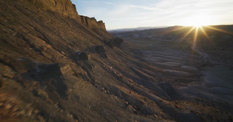 The sun shines brightly on a mountain ridge