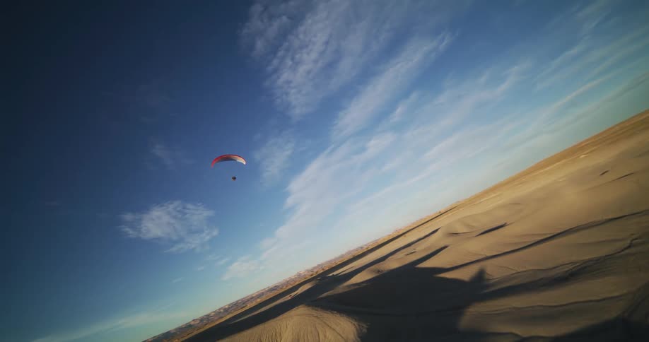 Person para sails through air over the desert