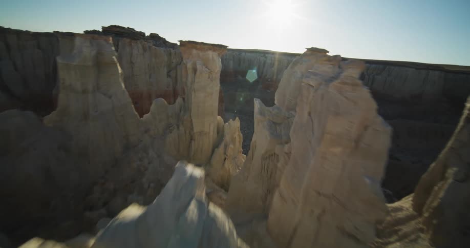 A person stands on the ledge of a large rock formation