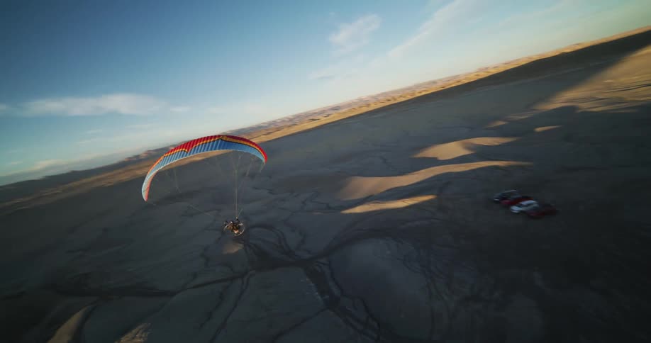 A person is gliding across an open landscape